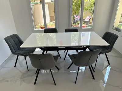 Modern white dining table with 6 grey upholstered chairs