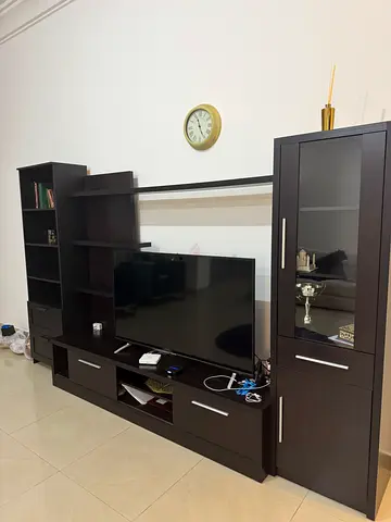 Dark wood TV entertainment center with glass cabinet and shelving