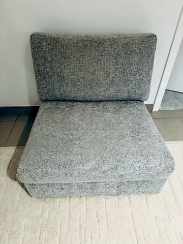 Single grey armless lounge chair / modular sofa piece