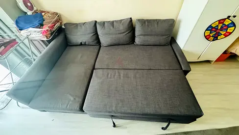 Grey L-shaped sofa bed with storage — good condition