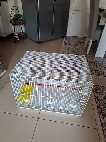 White metal bird cage with perch and feeder - good condition