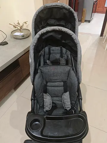 Grey double-seat baby stroller in good condition