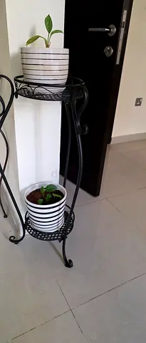 Black wrought iron 2-tier plant stand with pots and plants