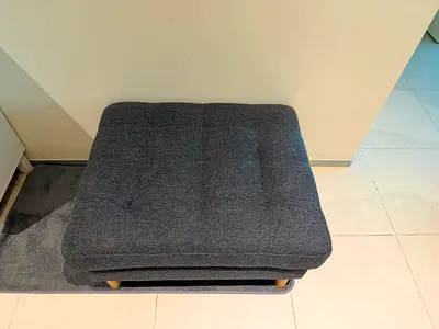 Gray upholstered ottoman / footstool in good condition