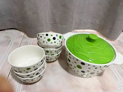 White ceramic casserole set with green lid and matching bowls