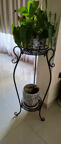 Two-tier wrought iron plant stand with decorative pots and plants included