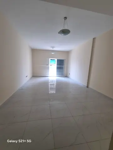 Two-bedroom apartment for rent in Al Nad, Al Qasimia, near Al Nad Park. Features three bathrooms, balcony, central AC, free parking, one month free, a