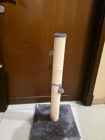 Tall sisal cat scratching post with plush base and hanging toys