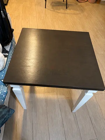 Small square wooden side table with dark top and white legs