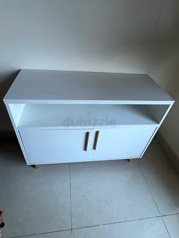 White freestanding cabinet with double doors and open shelf