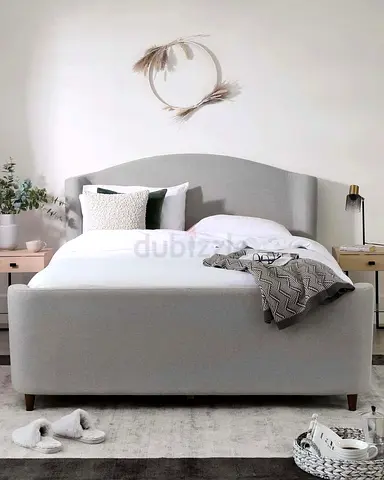 Light grey upholstered double bed with headboard and storage-style base