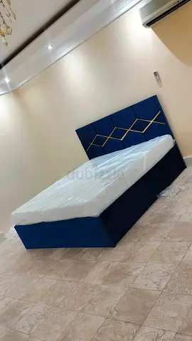 Blue upholstered queen bed with geometric headboard