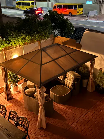 Outdoor garden dining set with gazebo and large square glass-top table and 6 chairs