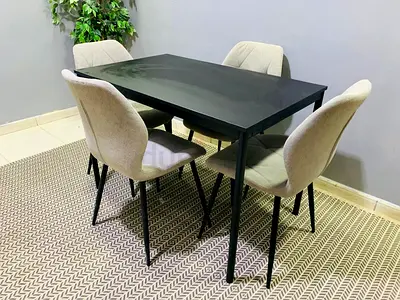 Modern black dining table with 4 beige upholstered chairs