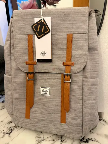 Light gray Herschel-style backpack with tan straps -