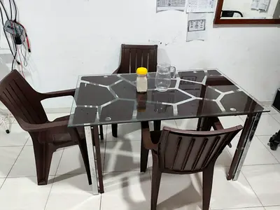 Glass-top dining table with 4 plastic chairs - compact set