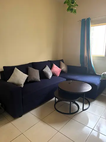L-shaped navy fabric sofa with cushions