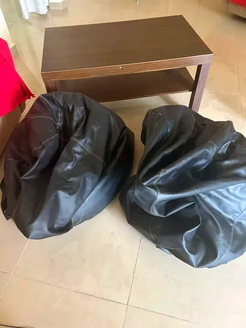 Small wooden coffee table with two black faux-leather bean bags