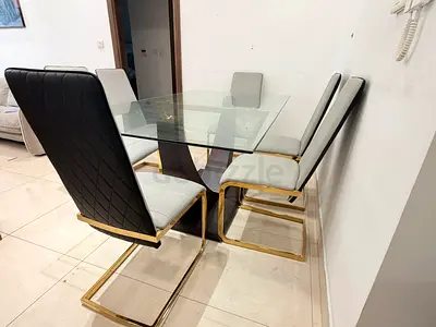 Glass Top Dining Table with 6 Quilted Black Chairs and Gold Frames