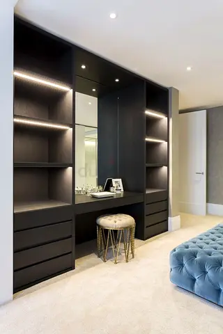 Built-in black wardrobe unit with vanity and LED shelves