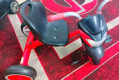Red toddler tricycle with handlebar and footrests - good used condition