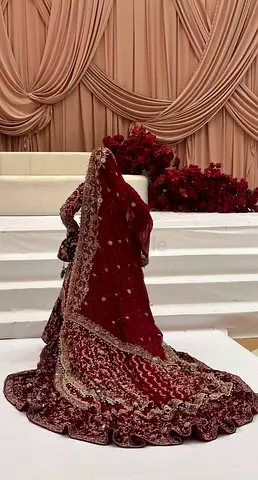 Maroon bridal lehenga with heavy embroidery - used for one main wedding event by the bride herself .