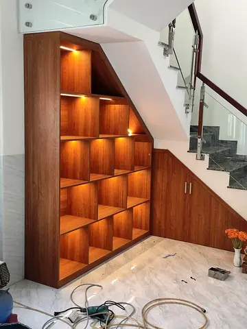 Custom under-stair wooden shelving unit with integrated lighting