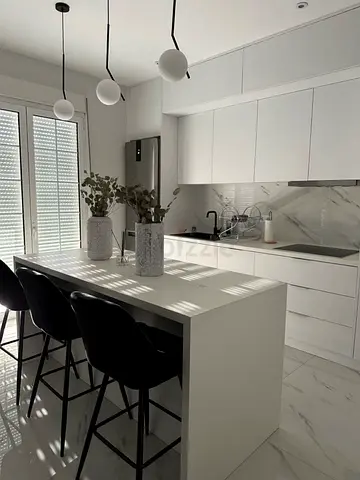 Modern white kitchen island with storage cabinets and wooden top