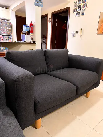 Comfortable 2-seater dark grey fabric sofa with wooden legs