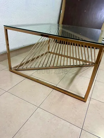 Gold metal and glass coffee table with geometric base