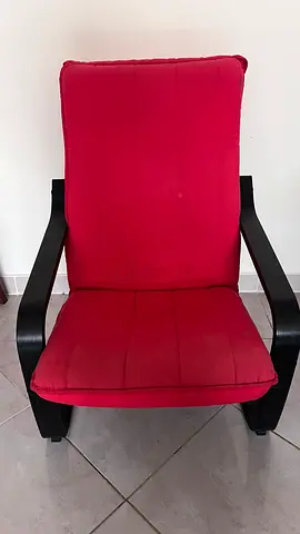 Red cushioned armchair with black wooden frame - good condition