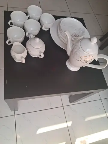 White ceramic tea set with teapot, cups and saucers - used