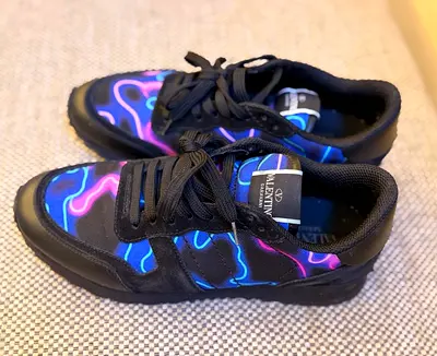 Valentino  sneakers feature a vibrant neon camouflage pattern in blue and purple