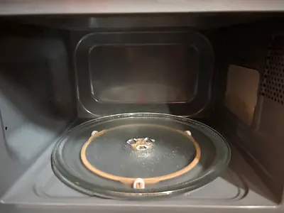Used microwave oven interior with glass turntable - working condition