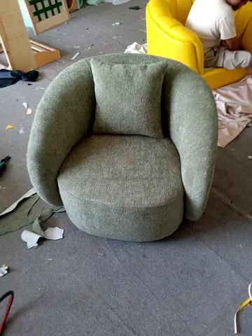 Compact green upholstered swivel lounge chair with cushion