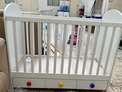 White wooden baby crib with storage drawers - good condition