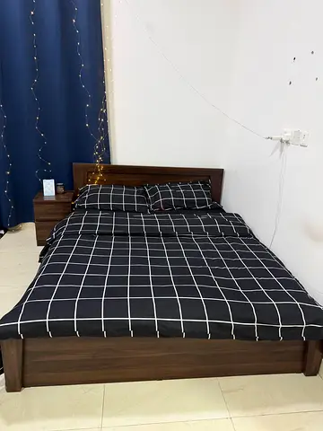 Dark wood double bed frame with headboard and matching bedside and mattress