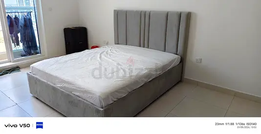Grey upholstered double bed with tall paneled headboard - good condition