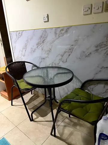 Glass-top bistro table with two outdoor chairs