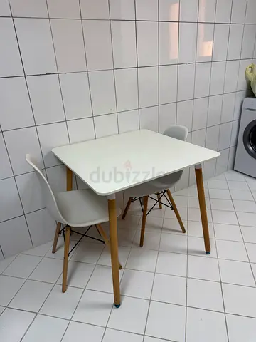 Compact white dining table with four molded chairs - modern set