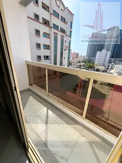 Two bedrooms, a living room, two bathrooms, and a balcony for rent in Al Rashidiya 2, next to Al Kon