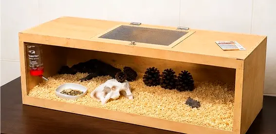 Wooden reptile/hamster enclosure with bedding, water bottle and hide