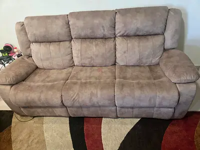 Comfortable brown 2 & 3 seater reclining sofas with a matching stool. Less than 2 years old.