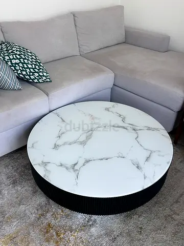Round marble-top coffee table with black ribbed base - good condition