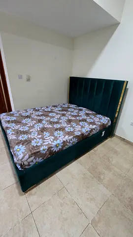 Green velvet double bed with upholstered headboard and storage