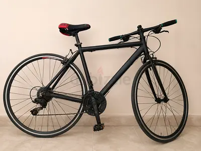 النوع: Hybrid / Fitness Bike (ليست Road سباق خالصة).
الإطار: ألمنيوم على الأغلب.
العجلات: 700C.
السر