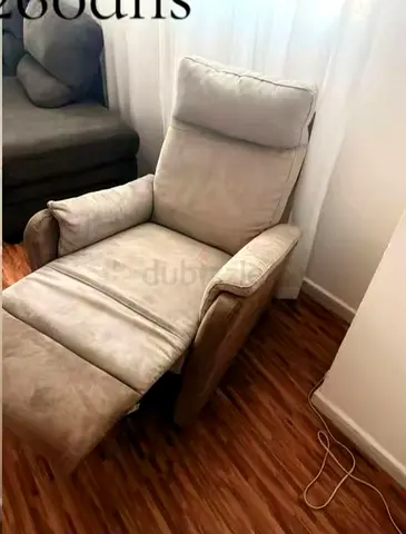 Comfortable beige reclining armchair with footrest