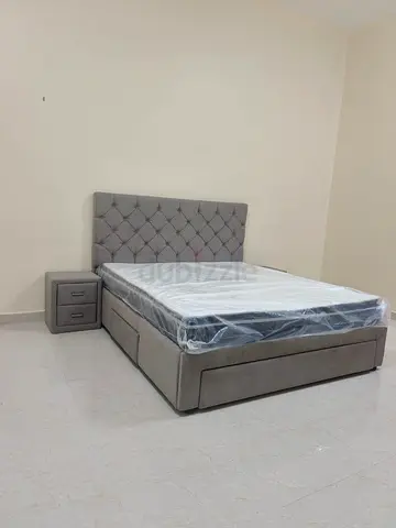 Grey upholstered storage bed with tufted headboard and bedside drawer