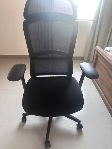 Ergonomic black mesh office chair with headrest and armrests
