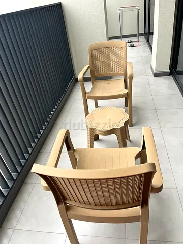 Set of 3 beige plastic patio chairs with small matching side table